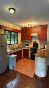 奈瓦沙Kwezi Cottage at The Great Rift Valley Lodge & Golf Resort Naivasha的一个带木制橱柜和冰箱的大厨房