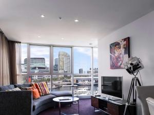 墨尔本The Sebel Melbourne Docklands Hotel的带沙发和大窗户的客厅