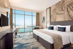 迪拜Wyndham Dubai Deira的一间酒店客房,设有一张大床和一个大窗户