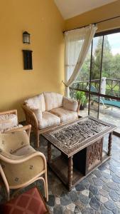 奈瓦沙Kwezi Cottage at The Great Rift Valley Lodge & Golf Resort Naivasha的带沙发和咖啡桌的客厅