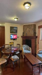 奈瓦沙Kwezi Cottage at The Great Rift Valley Lodge & Golf Resort Naivasha的客厅配有桌椅和壁炉
