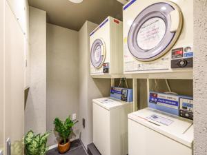 东京HOTEL LiVEMAX Asakusabashi-Eki Kitaguchi的室内的实验室,配有洗衣机和烘干机