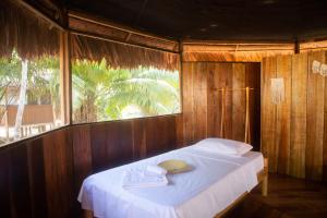 YucurucheEywa Lodge Amazonas - All inclusive的木制客房的一张床位,设有窗户