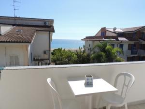 卡鲁尼亚玛丽娜B&B a due passi dal mare的阳台上配有白色的桌椅,享有海景