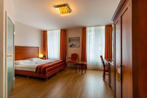 施韦尔姆穆莱泰奇酒店的卧室配有1张床、1张桌子和1把椅子