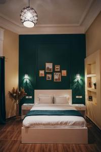 开罗Hathor House的一间卧室设有一张大床和绿色的墙壁