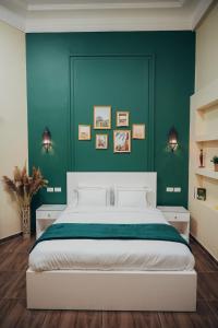开罗Hathor House的一间卧室设有一张大床和绿色的墙壁
