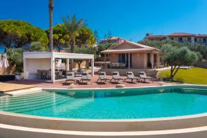 蒂锡利维Villa Carvella - A Sublimely Relaxing Escape!的一个带椅子的游泳池以及一座房子