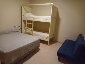 圣拉斐尔Privilegio Hostel的一间卧室配有两张双层床和一张蓝色椅子