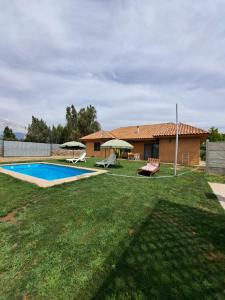 El RincónCasa de campo Mostazal / Hogar para descansar的一个带游泳池和房子的庭院