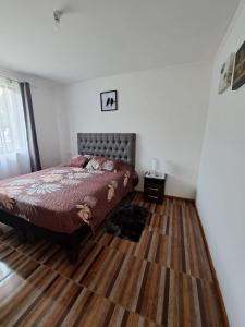 El RincónCasa de campo Mostazal / Hogar para descansar的一间卧室配有一张床,铺有木地板