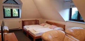 高塔特拉山Vila Jedľa的一间卧室配有两张床、椅子和两个窗户。
