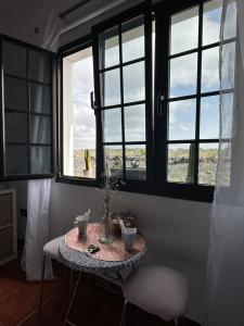 蒂亚斯Habitación Dache Lanzarote的带三扇窗户的房间里一张桌子