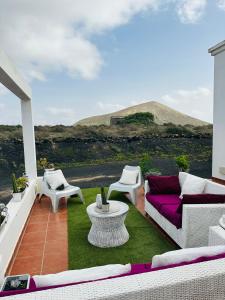 蒂亚斯Habitación Dache Lanzarote的庭院配有紫色的沙发、桌子和椅子