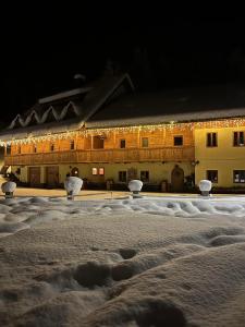 克拉尼斯卡戈拉Hotel ŠURC的一座晚上被雪覆盖的建筑,有灯光
