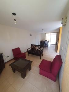 圣萨尔瓦多德朱Alq Toba- Hermoso Duplex en Bajo la Viña的客厅配有红色椅子和桌子