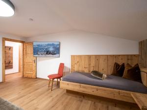 伊特尔Bauernhof Vordermühltal的一间卧室配有木床和红色椅子