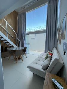 阿拉沙Ybira Loft的带沙发和大窗户的客厅