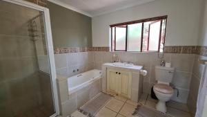 白河Robin Cottage Da Gama Lake的浴室配有卫生间、盥洗盆和淋浴。