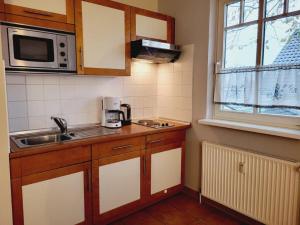奥斯赛拜-屈隆斯博恩Appartementhaus Ulmenschloesschen的一间带水槽和微波炉的小厨房