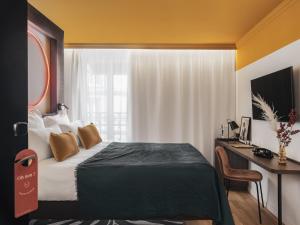 巴黎赛文酒店的酒店客房配有一张床和一张带电脑的书桌