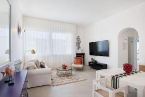 Plaia GrandeVilla LAVINIA MARE E PISCINA PRIVATA的白色的客厅配有白色的沙发和电视