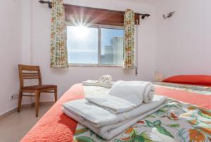 拉戈斯Falesia Apartment by Seewest的一间卧室配有带毛巾的床和窗户。