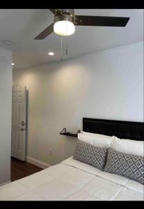费城Private Luxe Room A Hidden Gem With Private Bath & Kitchen的卧室配有白色的床和吊扇