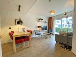 登霍伦Appartementen Bos en Duin Texel的厨房以及带桌椅的起居室。