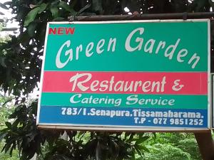 蒂瑟默哈拉默New Green Garden Hotel & Safari的绿色花园和餐厅标志及餐饮服务