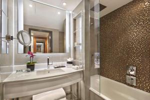 伦敦Hyatt Regency London Albert Embankment的一间带水槽、镜子和淋浴的浴室