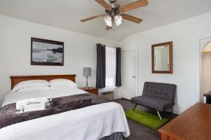泰特斯维尔Travel Inn of Titusville的一间卧室配有一张床、一把椅子和吊扇