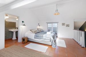 阿尔科谢蒂Casa da Praia的白色卧室设有床铺和水槽