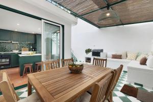 阿尔科谢蒂Casa da Praia的厨房以及带木桌和椅子的客厅。