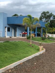 伊瓜苏Chacara Beach Lazer的一座蓝色的建筑,前面有棕榈树