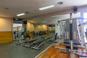 科尔多瓦Quinto Centenario Hotel的健身房设有许多跑步机和镜子