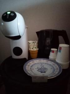San Demetrio CoroneLa Giara B&B的咖啡壶和餐桌上的盘子,带咖啡壶