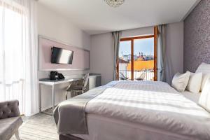 维斯普雷姆西斯托马洛科特酒店的配有一张床、一张书桌和一扇窗户的酒店客房