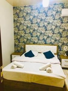 巴统Nana's House的一间卧室配有一张蓝色和白色壁纸的床