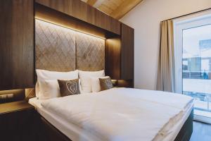 萨尔巴赫GLEMM by AvenidA Superior Hotel & Residences的卧室配有一张大白色床和窗户