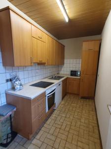 维利希Ferienwohnung Linden 87的厨房配有木制橱柜和白色炉灶烤箱。
