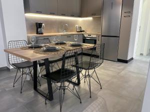 雅典Anneta’s home的厨房配有桌椅和冰箱。