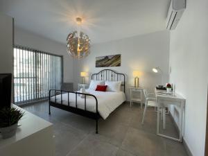 圣朱利安斯Casa Leon Malta的一间卧室配有一张床、一张桌子和一张书桌