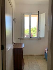 新福卡Villa Delfino的一间带木桌和两个窗户的浴室