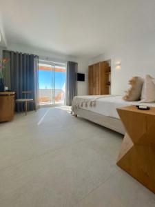 米克诺斯城Calistus Mykonos的一间卧室配有一张床,享有海景