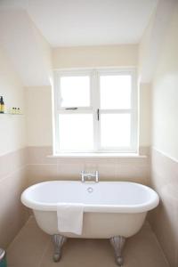 斯莱恩The River House的带窗户的浴室内的白色浴缸