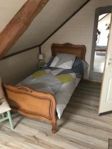 Rigny-la-NonneuseLa Grange Aux Fleurs的阁楼上的卧室配有一张大床