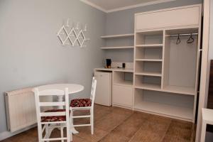 新彼得罗波利斯维拉韦德酒店的厨房配有桌子、椅子和书架