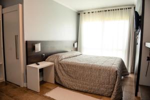新彼得罗波利斯维拉韦德酒店的一间小卧室,配有床和窗户