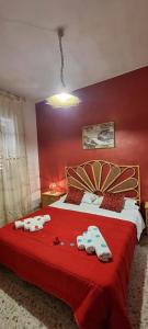 法尔科内Le Stelle Del Tirreno的红色卧室,配有带毛巾的床